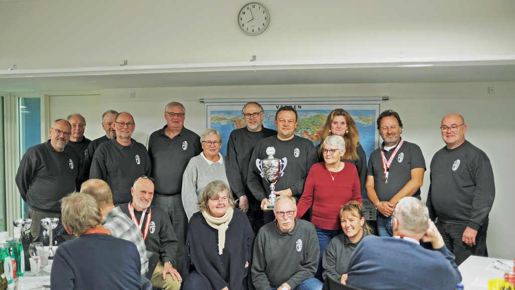 Danmarksmestrene 2024 i Regularity løb for klubhold fra Sports Motor Klubben Gladsaxe, ses her ved præmieoverrækkelsen til finalen i Lemvig – løbsleder for 2. afd. 2025, Kim Bach Sørensen ses med pokalen for mesterskabet i 2024
(Foto: rallypics.dk / Viggo Johansen)